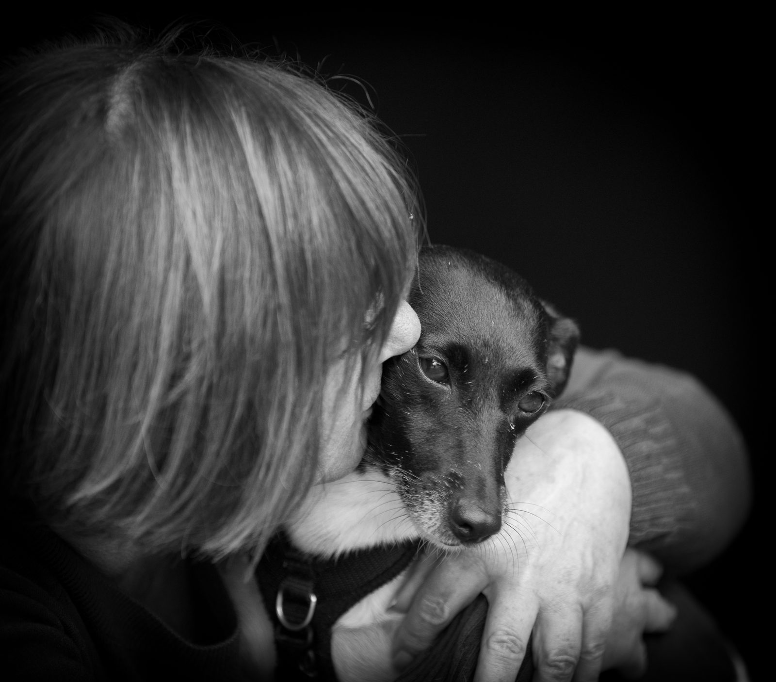 Dawn holding Millie, her black-and-white Jack Russell, close in a black-and-white photograph