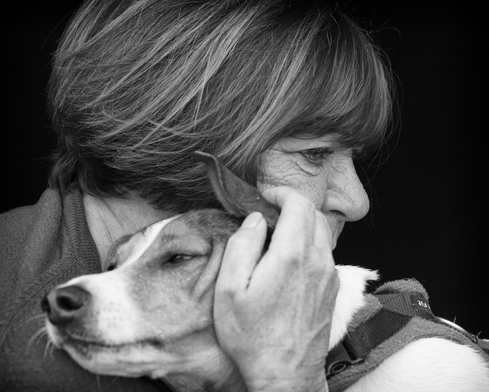 Dawn holding Mylo, her tan-and-white Jack Russell, close to her cheek