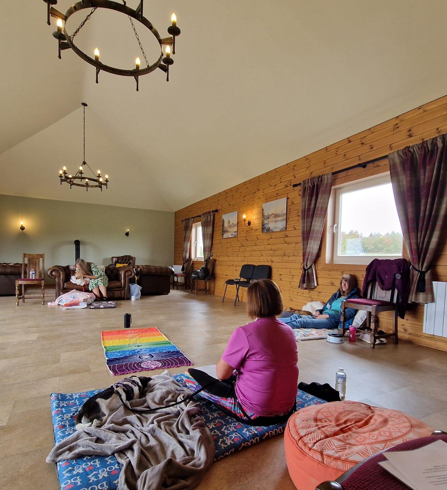 Guardians and their dogs settling together on blankets during a retreat session